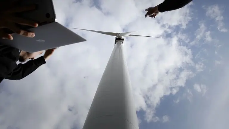 Ingenieure pr&uuml;fen eine moderne Windkraftanlage.